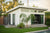 Exterior of a white Studio Home 10x12 Summit ADU with sliding glass doors, landscaped lawn, and pool in Scottsdale, Arizona.